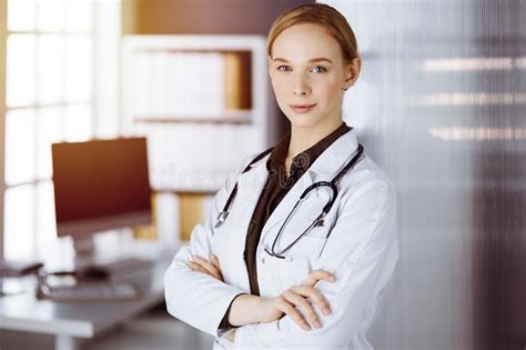 Cheerful Smiling Female Doctor Standing In Clinic Portrait Of Friendly