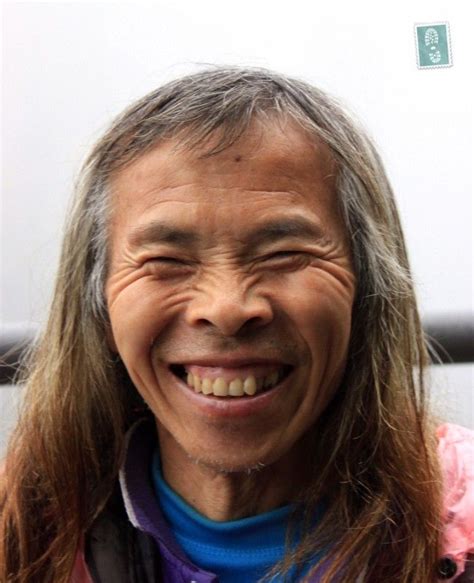 An Old Man With Long Hair Smiling At The Camera