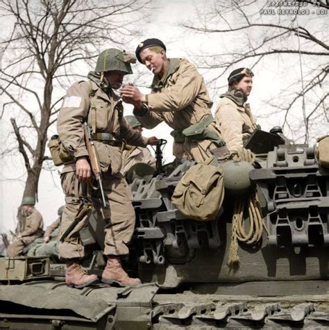 Men In Uniforms Are Sitting On Top Of A Tank