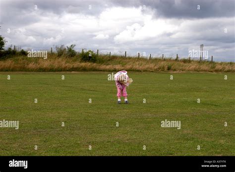 Little Girl Bending Over In A Field Stock Photo Alamy