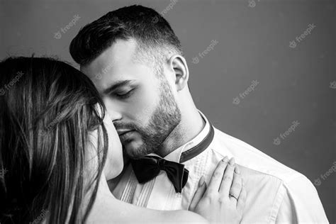 若いガールフレンドとボーイフレンドにキスする美しい情熱的なセクシーなカップルのクローズアップ プレミアム写真