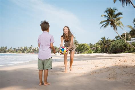 Feliz Joven Hermosa Madre E Hijo Jugando A La Pelota En La Playa En Un