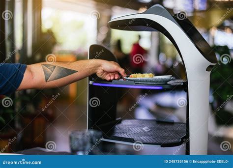 Robot Waiter Serving Food In A Restaurant Taking Food From A Waiter