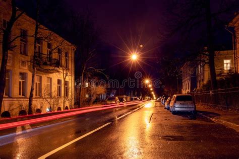 Night City Street With Lights Of Passing Car Trees And Street Lamps