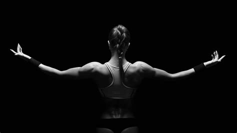 Dedication, determination, overcoming and perseverance. Athletic young woman showing muscles of the back ...