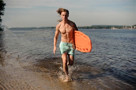 Premium Photo Attractive Sexy Beach Lifeguard Running Along The River Bank With Life Saving