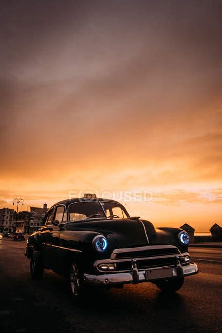 Vintage Car Driving Down Road In Sunset — Vertical Roadway Stock