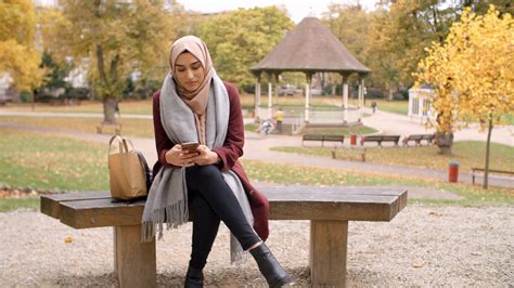 British Muslim Woman Texting On Mobile Phone In Park Stock Video Footage 0015 Sbv 312842468