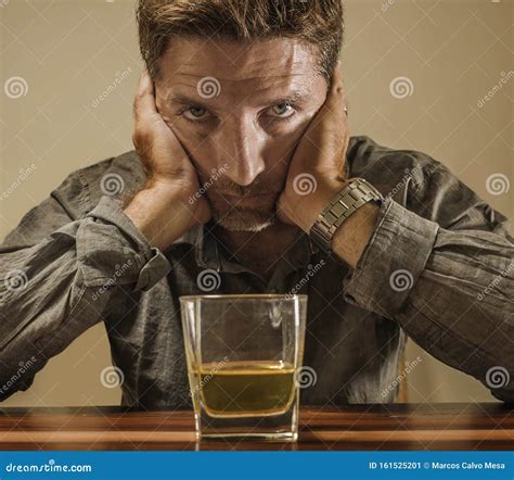 Depressed And Thoughtful Alcoholic Man On His 40s In Front Of Whiskey