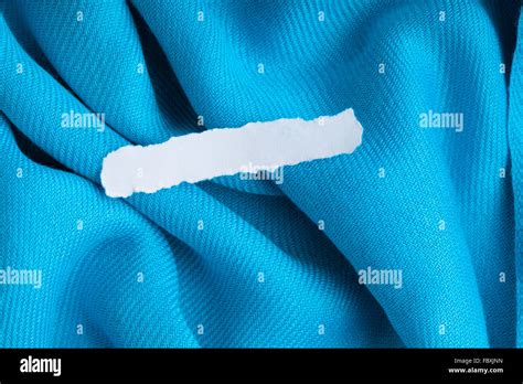 Blank Scrap Of Paper On Blue Cloth Wavy Folds Textile Background Stock