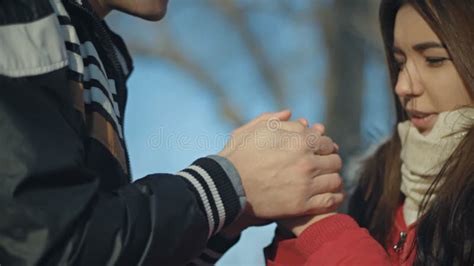 A Man Warms His Girlfriend S Hands By Taking Them In His Woman In Lilac Wreath Stock Footage