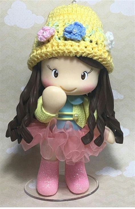 A Small Doll Wearing A Yellow Hat And Pink Dress
