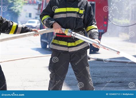 Firefighters Holding Firehose To Extinguish Fire Stock Photo Image Of