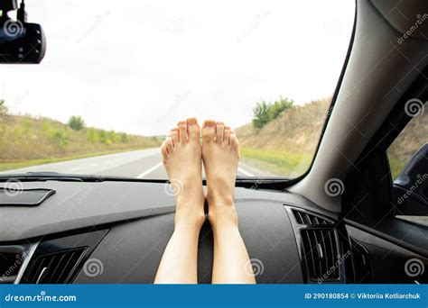 Womenand X27s Bare Feet Lie On The Dashboard In A Car That Drives Along