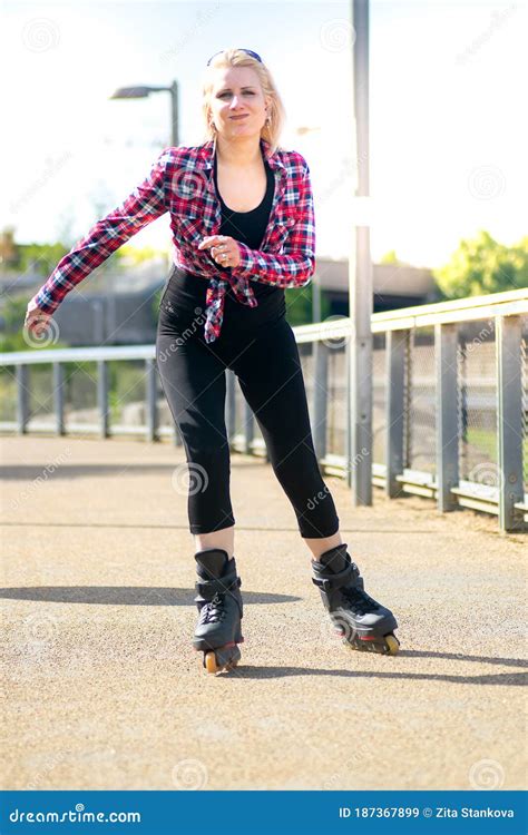 Blonde Woman Roller Skating On The Pavement Outdoors Stock Image