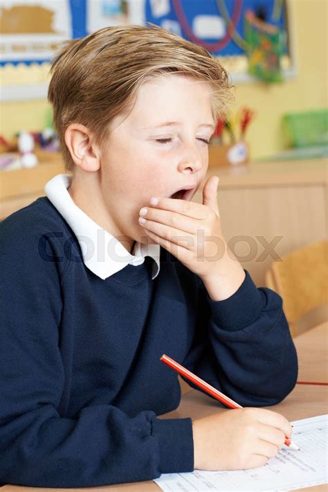 Male Elementary School Pupil Yawning In Classroom Stock Image Colourbox