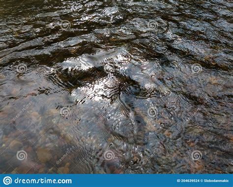 Wavy Ripple Surface Of Water On Shallow Rapid Stream With Colorful