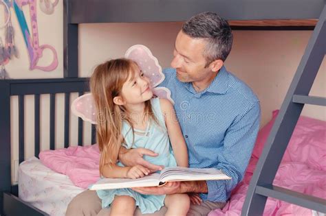 Papá Leyendo Un Libro A La Pequeña Hija Familia Feliz De Dos Sentados