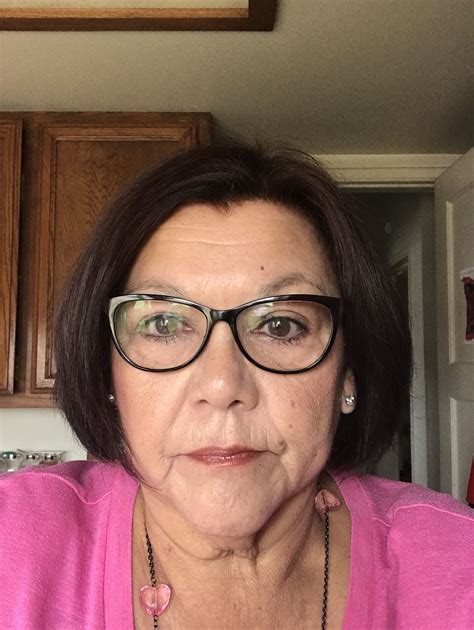 an older woman wearing glasses in a kitchen