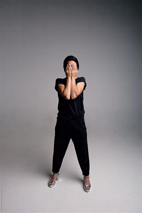 Unrecognizable Woman In Casual Clothes Covering Face With Hands By Stocksy Contributor Danil