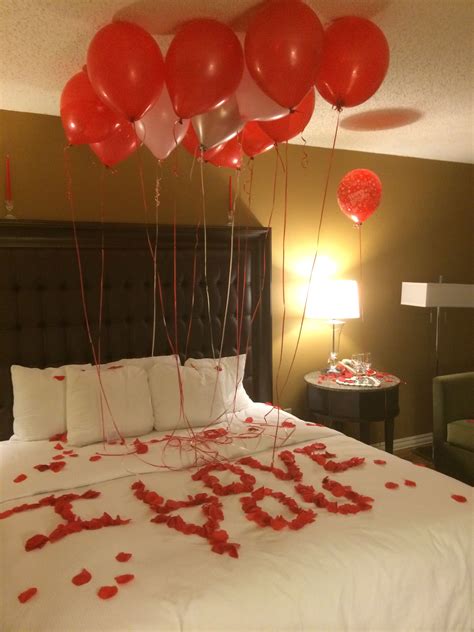 A Bed With Red And White Balloons Floating Over It