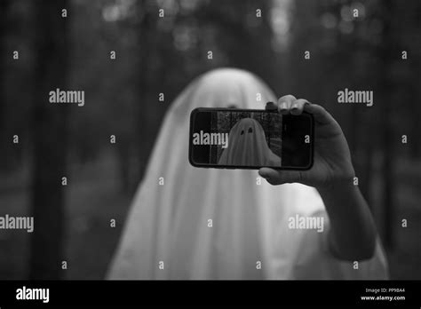 Woman In Halloween Ghost Costume Make Selfie In The Forest Stock Photo