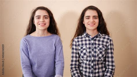 Two Twins Sisters Teenage Cute Girls With Curly Hairs Sit Along Watch