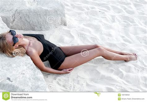 Beautiful Tanned Woman In Black Swimsuit On The Beach Stock Photo