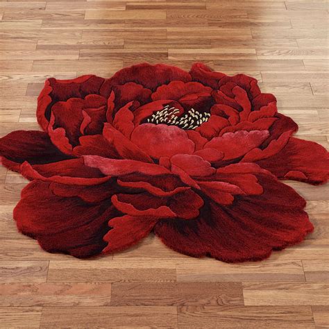 A Large Red Flower Sitting On Top Of A Wooden Floor
