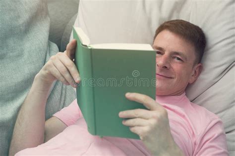 Man Lying On Couch And Reading A Book Stock Photo Image Of Studying