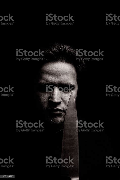 Portrait Of Angry Young Man Holding Knife Low Key Stock Photo
