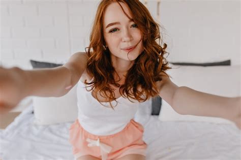 Free Photo Winsome Ginger Girl With Pale Skin Making Selfie In Bedroom Indoor Photo Of