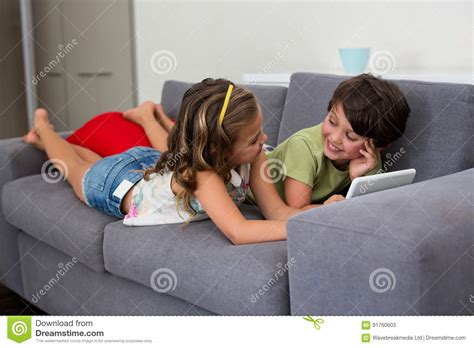 siblings interacting with each other while using digital tablet stock image image of couch