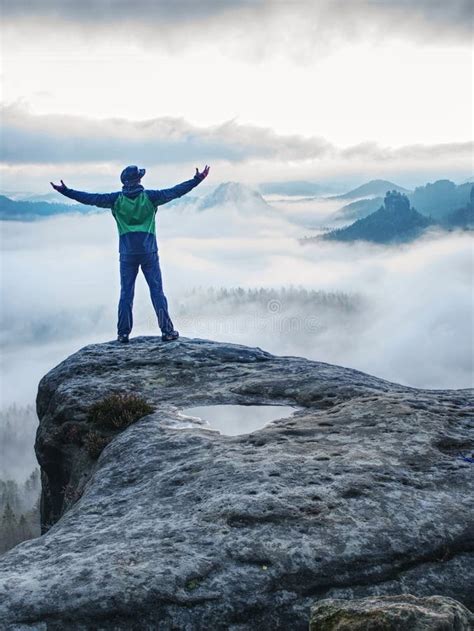 Man Finnaly Standing On Rock And Enjoy Foggy Mountain View Stock Photo
