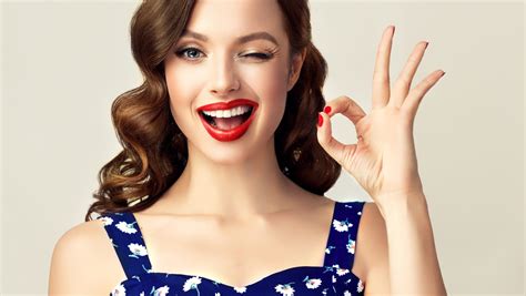 Pin Up Retro Girl With Curly Hair Winking Smiling And Showing Ok Sign