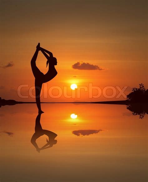 Silhouette Of A Beautiful Yoga Girl On Mirrored Sunset