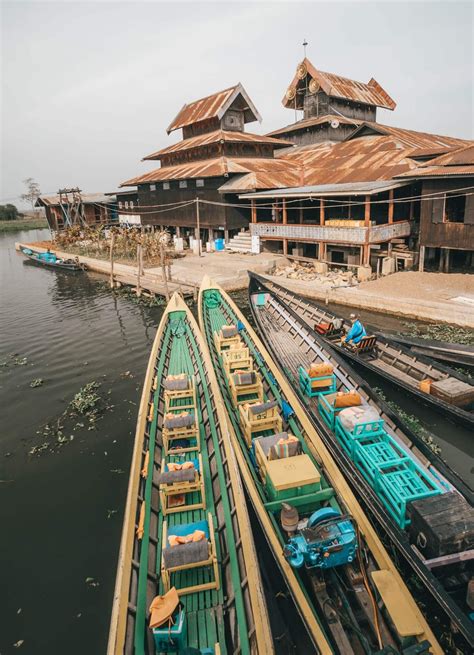 Boats Are Lined Up In Front Of A Building On The Water Near Another
