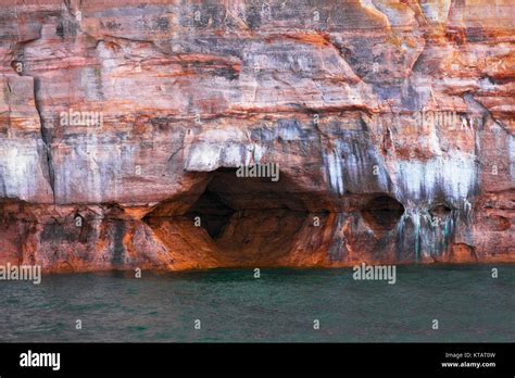 Naturally Formed Caves Among The Mineral Seep Sandstone Cliffs On Lake