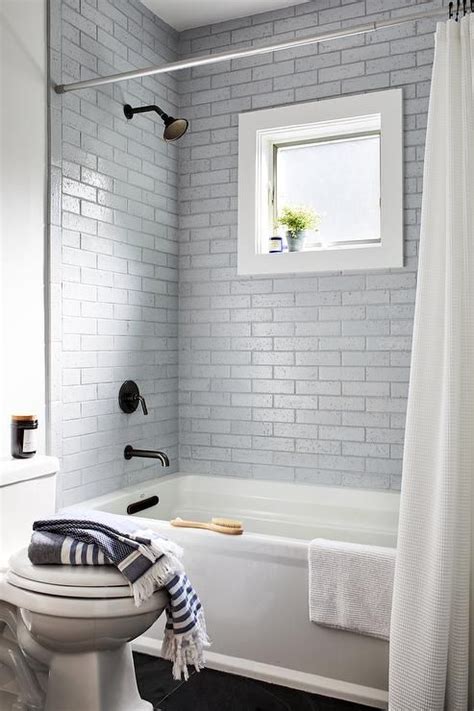 Marble adds a touch of the roman spa decadence, while fluid grey river stones suggest an extension of the natural surrounding environment. A white basketweave shower curtain hangs in front of a ...