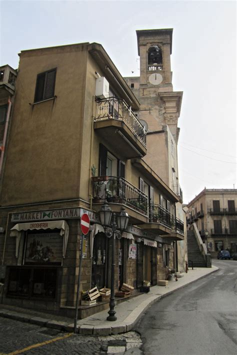An Old Building With A Clock Tower In The Middle Of Its Side Walk