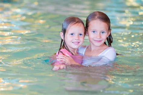 Adorable Little Girls In Swimming Pool On Summer Vacation Stock Image