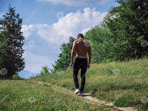 Photo Of A Shirtless Man Walking Along A Rustic Dirt Path Stock Image