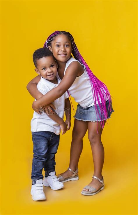little black brother and sister cuddling and posing on yellow background stock image image of