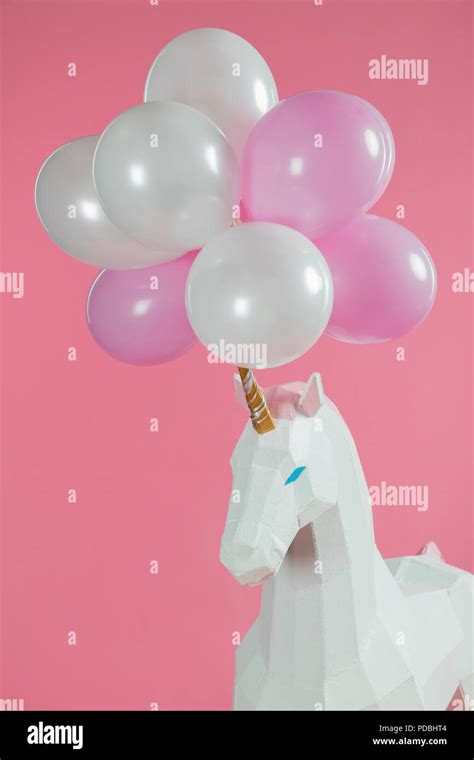 Bunch Of Air Balloons On Horn Of Toy Unicorn Isolated On Pink Stock