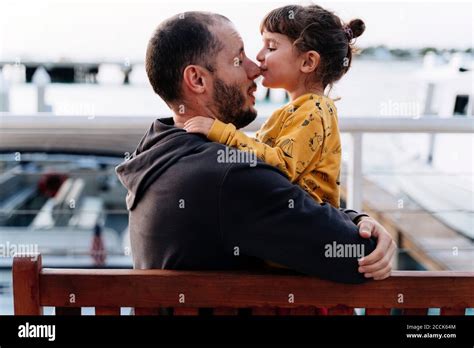 Father Embracing While Daughter Kissing Him On Nose In City Stock Photo