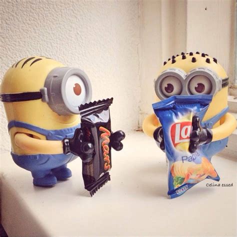 Two Toy Minion Figures Holding Candy Bars