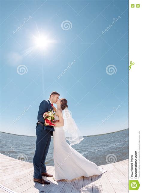 Young Wedding Couple Kissing On Pier Stock Photo Image