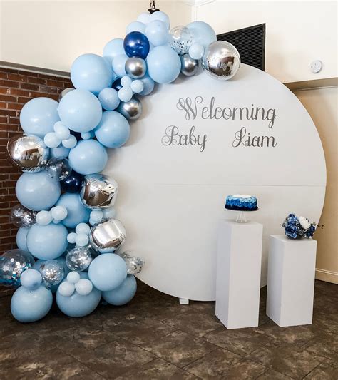 Round Wall Backdrop With A Large Organic Balloon Garland And Pedestals
