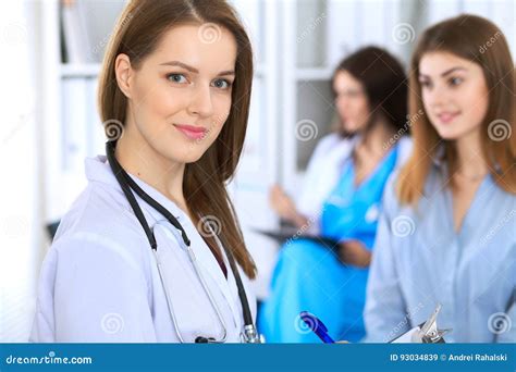 Young Beautiful Female Doctor Smiling To Patient While Consulting Her