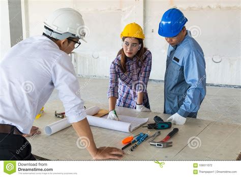 Construction Team Architect Engineer And Foreman Discussing Stock